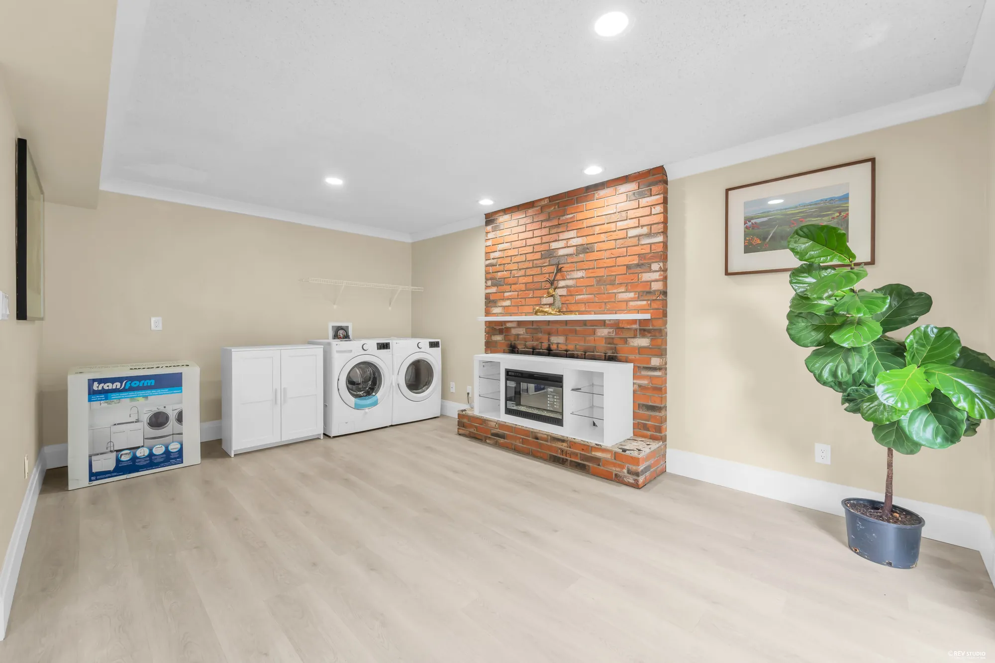 The family room looking toward the washer and dryer in the corner beside the brick fireplace