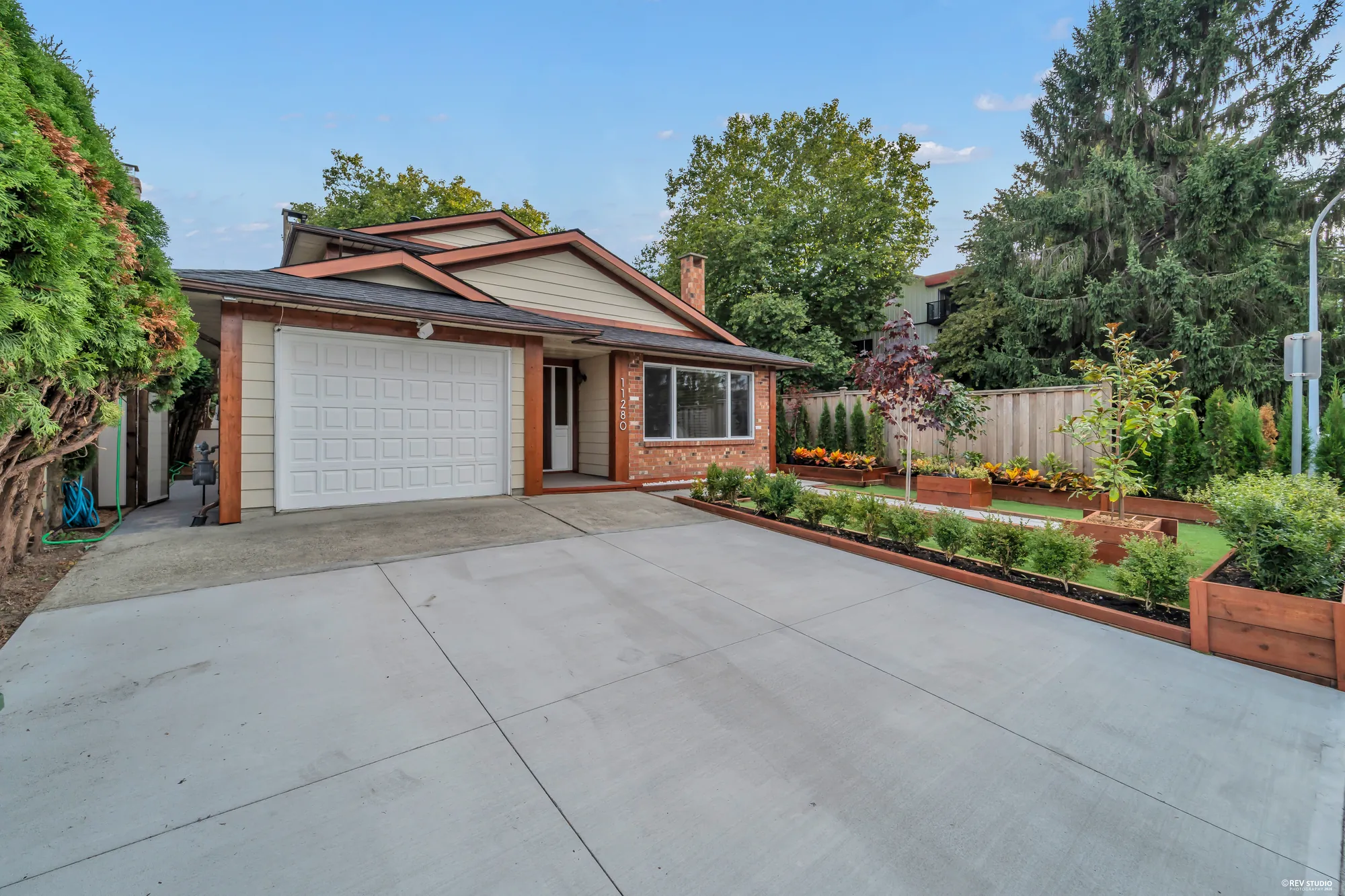 The garage door and the entry from the drive, the raised beds to the right