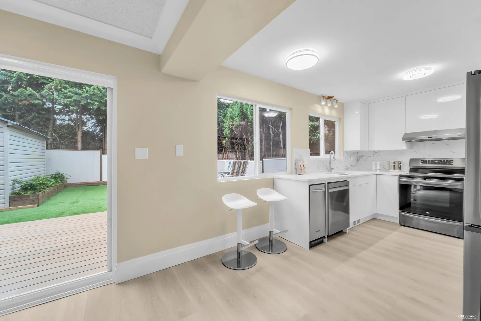 The kitchen wide with the door to the deck on the left and the breakfast stools at the counter