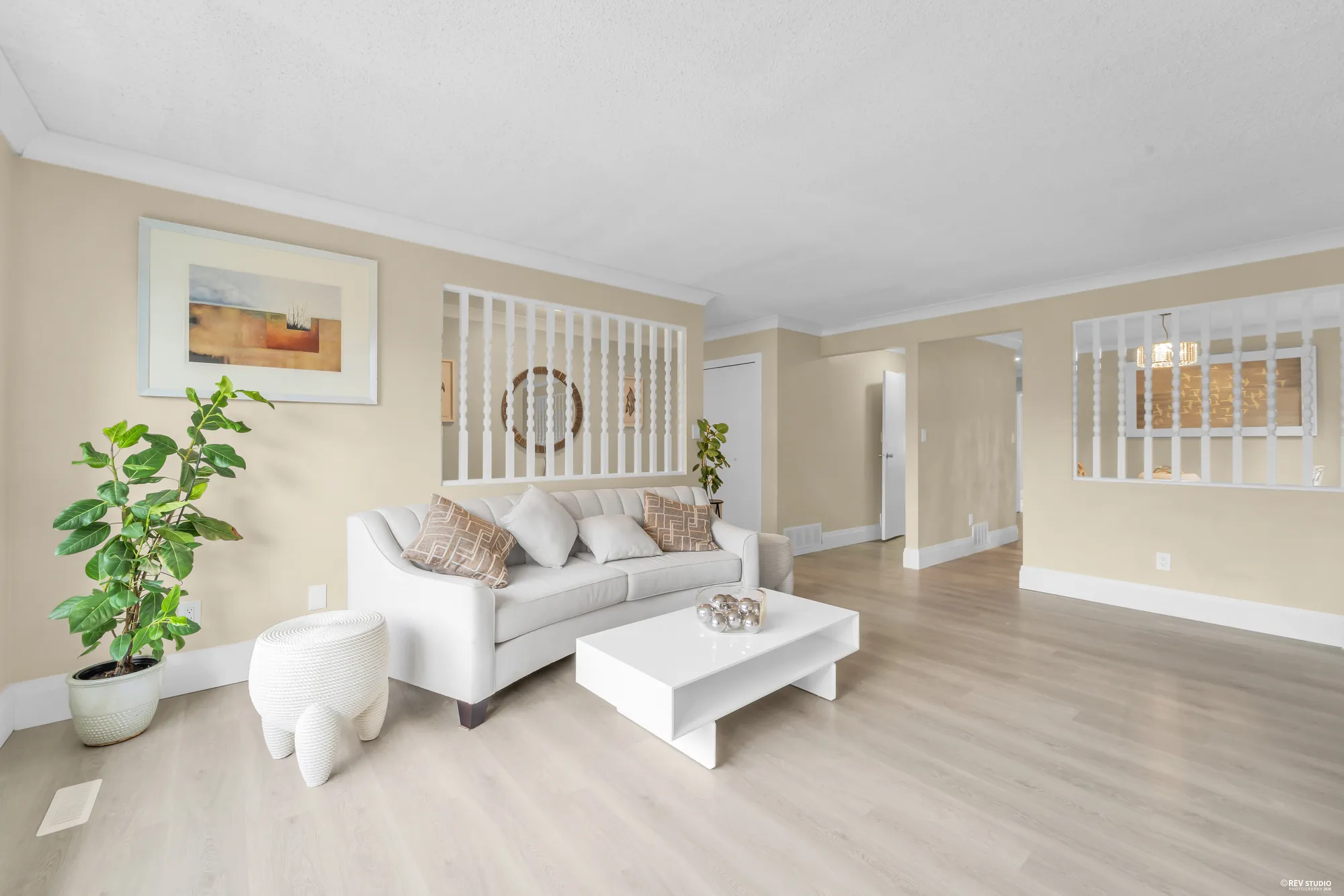 The living room from the entry, the sofa facing the fireplace and the dining screen beyond