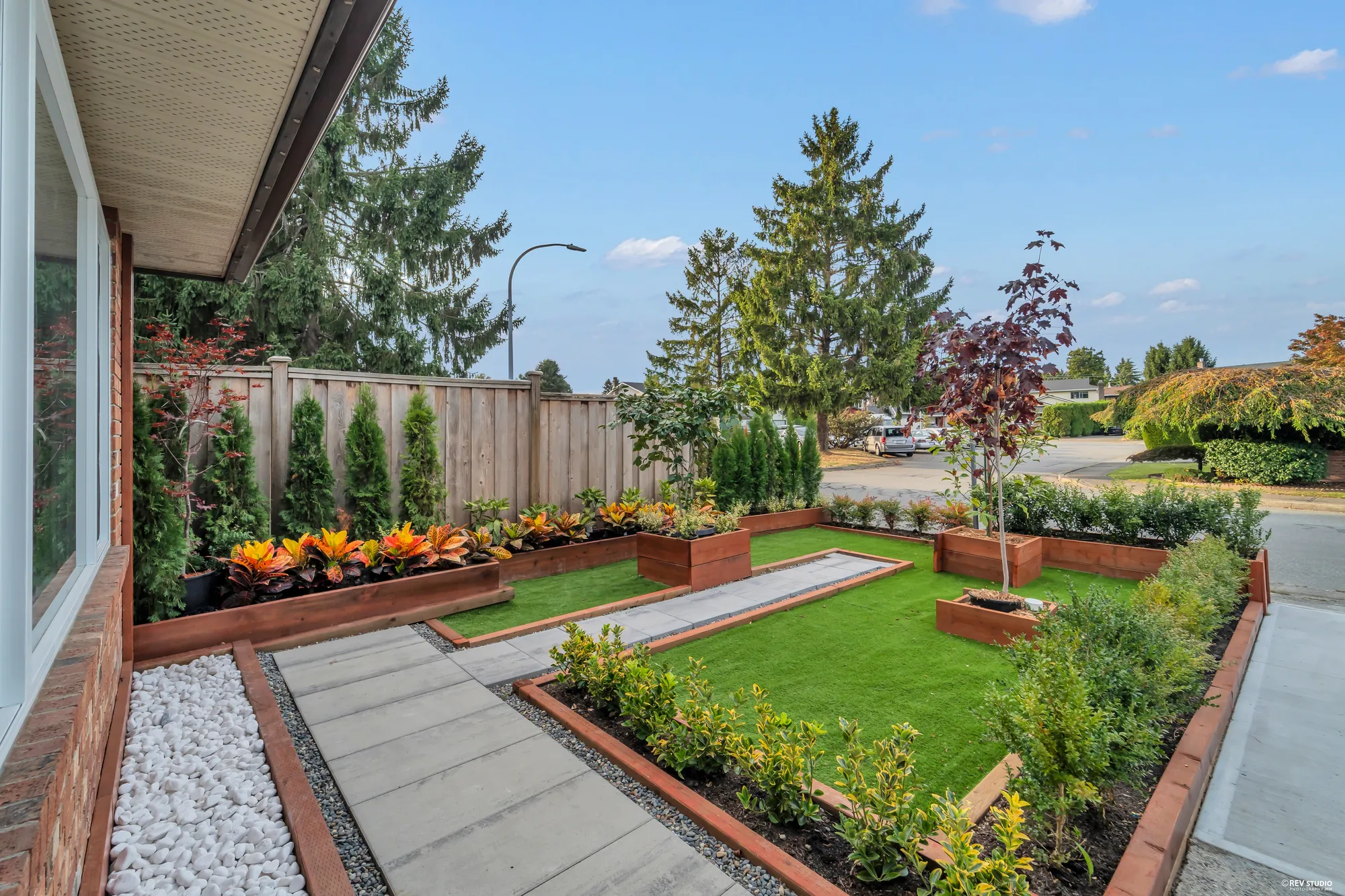 From beside the front window, looking over the beds and the turf to the street corner