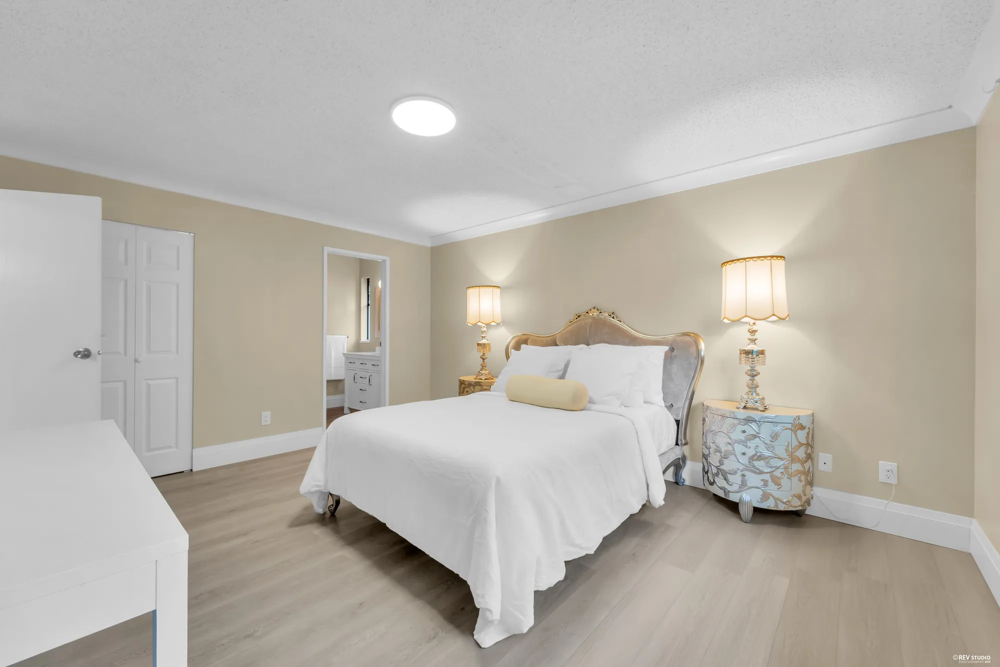 The primary bedroom toward the door, the walk-in and the bathroom beyond