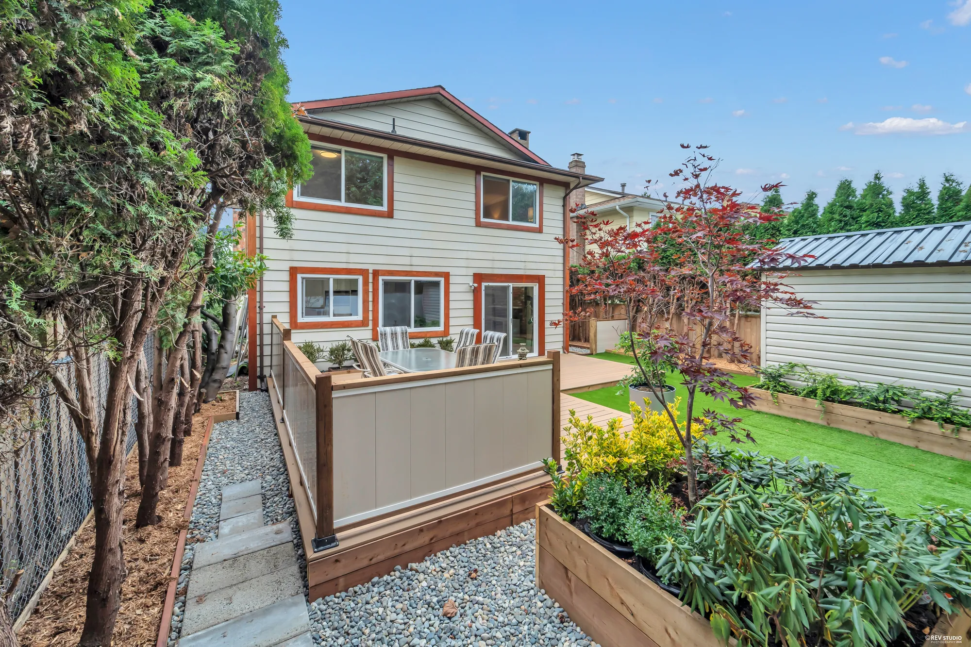 The side of the house looking to the back, the shed and the planting bed along the fence